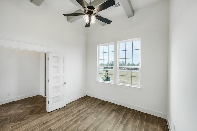 unfurnished bedroom with beamed ceiling, hardwood / wood-style floors, a high ceiling, and ceiling fan