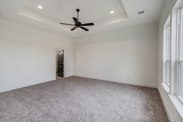 spare room with ceiling fan, a raised ceiling, and carpet flooring