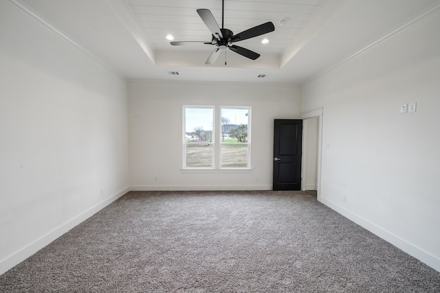 carpeted spare room with ceiling fan, a raised ceiling, and crown molding