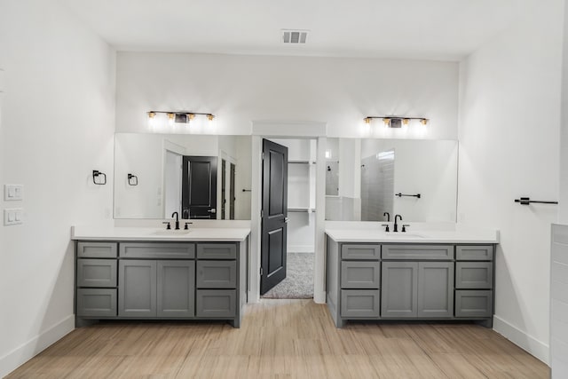 bathroom featuring walk in shower, hardwood / wood-style floors, and vanity