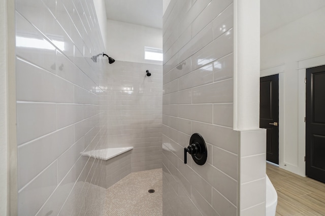 bathroom featuring hardwood / wood-style flooring and a tile shower