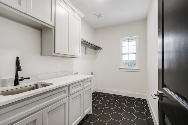 washroom featuring cabinets, sink, and dark tile patterned flooring