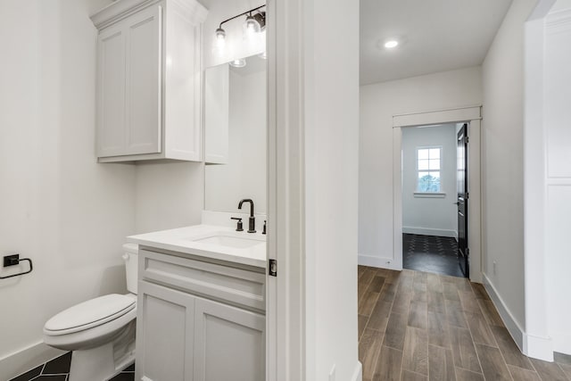 bathroom with hardwood / wood-style flooring, vanity, and toilet