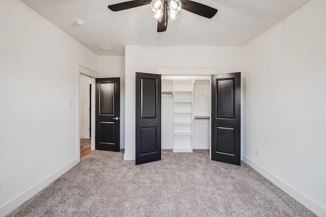 unfurnished bedroom featuring ceiling fan, a closet, and light colored carpet