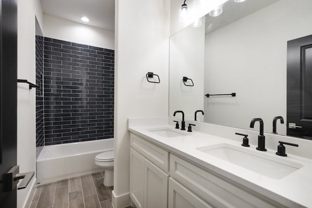 full bathroom with vanity, toilet, and tiled shower / bath combo