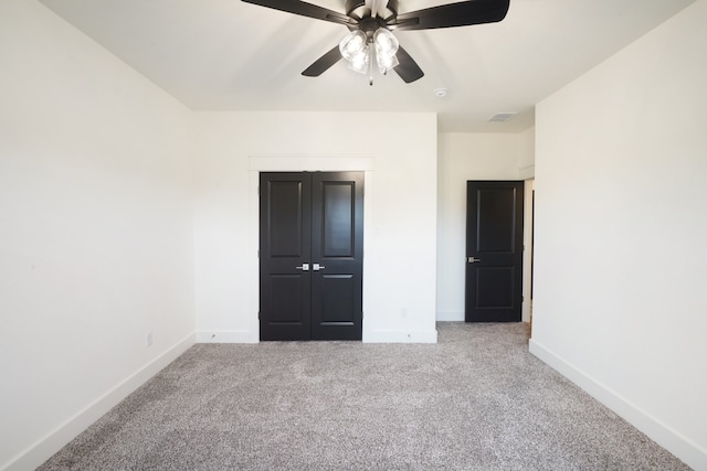 unfurnished bedroom with ceiling fan, carpet floors, and a closet