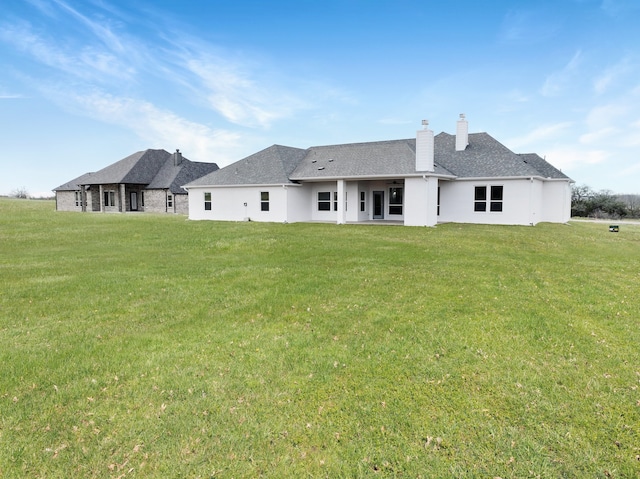 rear view of property featuring a lawn