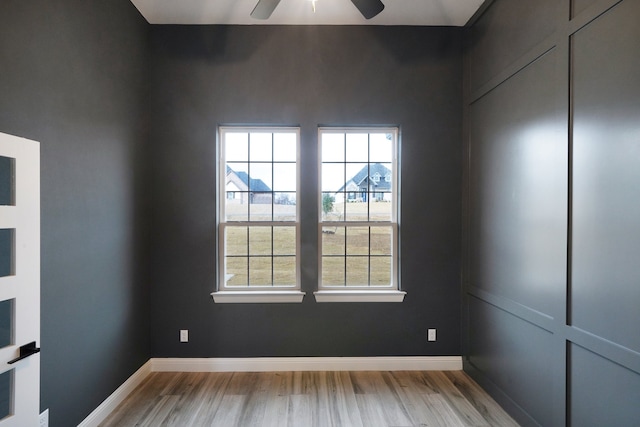 spare room featuring ceiling fan, light hardwood / wood-style floors, and a healthy amount of sunlight