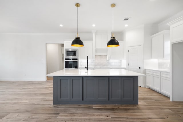 kitchen with appliances with stainless steel finishes, light hardwood / wood-style flooring, and white cabinets