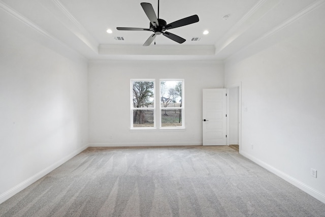 unfurnished room with crown molding, a tray ceiling, light colored carpet, and ceiling fan