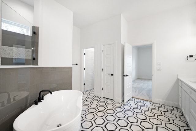 bathroom with independent shower and bath, vanity, and tile patterned flooring