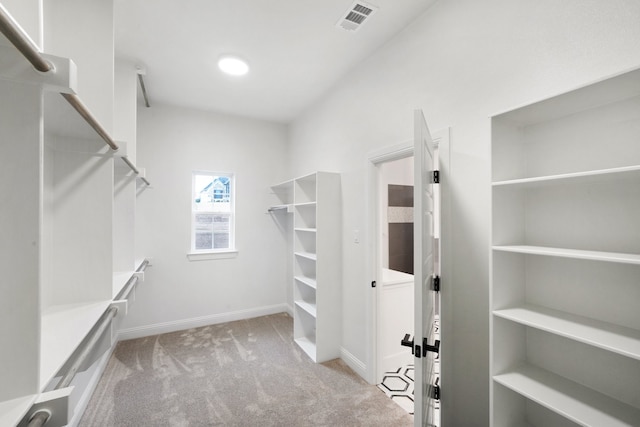 walk in closet featuring light carpet