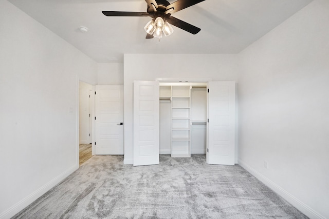 unfurnished bedroom featuring ceiling fan, a closet, light carpet, and a walk in closet