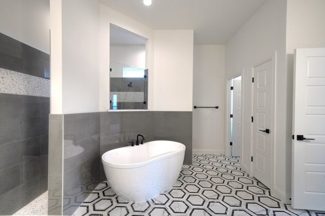 bathroom featuring tile patterned floors, tile walls, and independent shower and bath