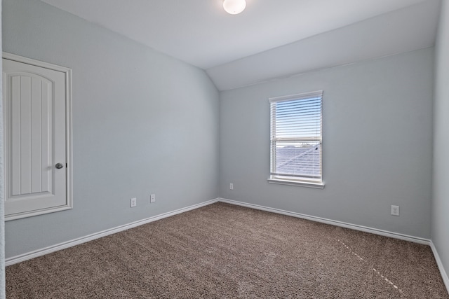 carpeted spare room featuring lofted ceiling