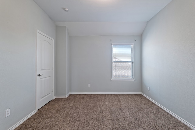 spare room with carpet and vaulted ceiling