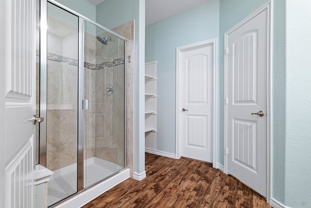 bathroom with an enclosed shower and wood-type flooring