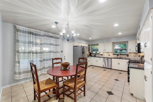 tiled dining space featuring sink and a chandelier