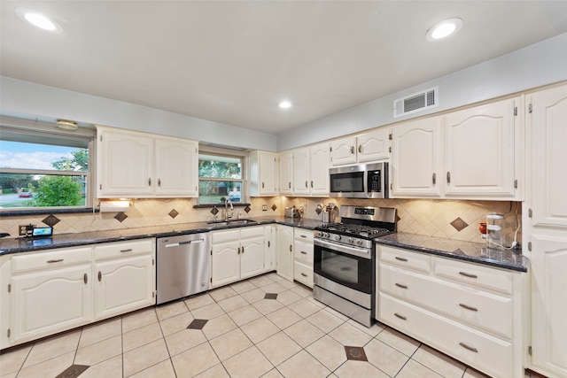 kitchen with white cabinetry, stainless steel appliances, sink, and plenty of natural light