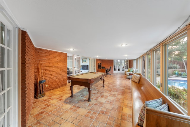 rec room with brick wall, ornamental molding, and pool table