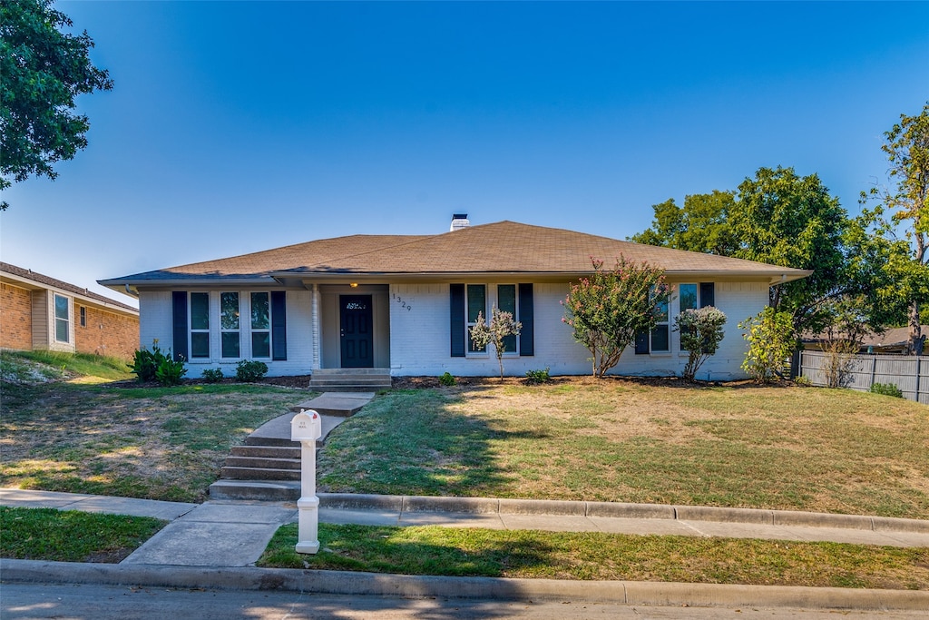 single story home featuring a front lawn