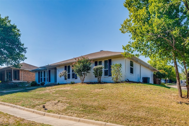 ranch-style house featuring a front lawn and central AC unit