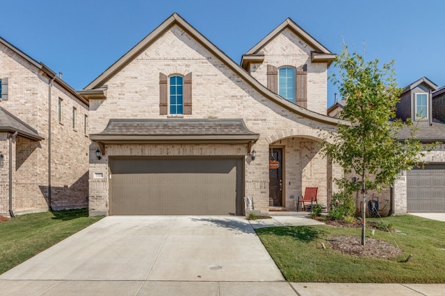 view of front of property featuring a front yard and a garage