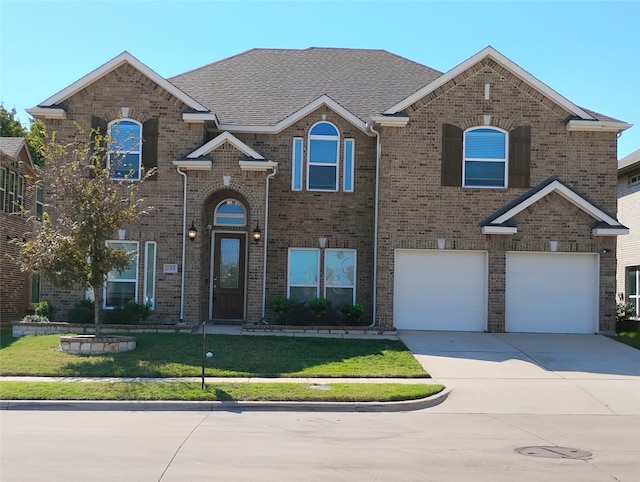 view of front of property featuring a front lawn and a garage