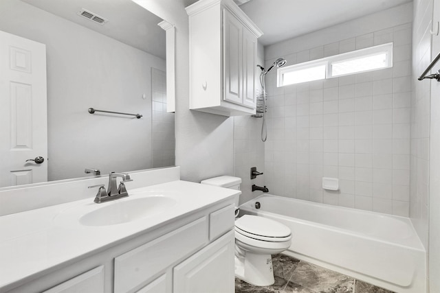 full bathroom with vanity, tiled shower / bath combo, and toilet