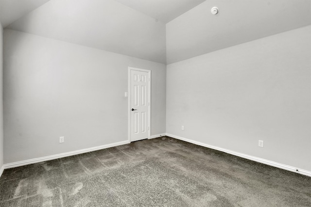 carpeted empty room featuring vaulted ceiling