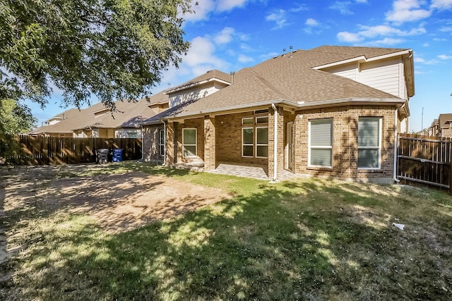 rear view of house featuring a patio and a yard