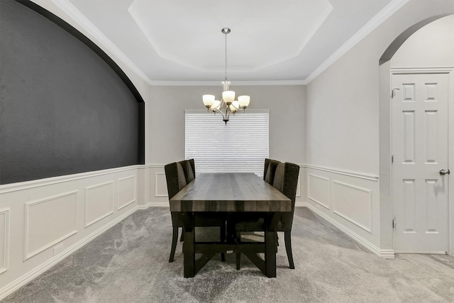 dining room with light carpet, crown molding, and a chandelier