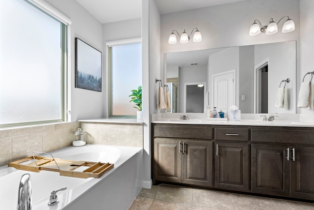 bathroom featuring tile patterned flooring, a tub to relax in, and vanity