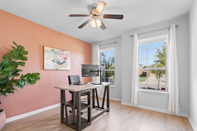 office with light hardwood / wood-style floors and ceiling fan