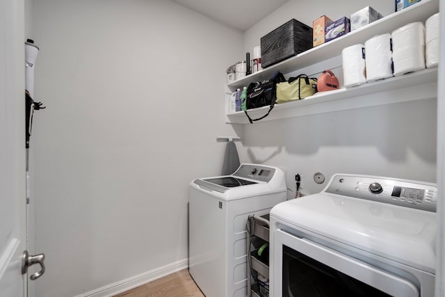 washroom featuring washing machine and dryer and light wood-type flooring