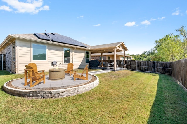 back of property featuring a yard, a patio area, and solar panels