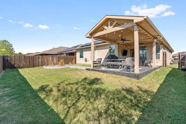 rear view of house with a yard, a patio area, and ceiling fan