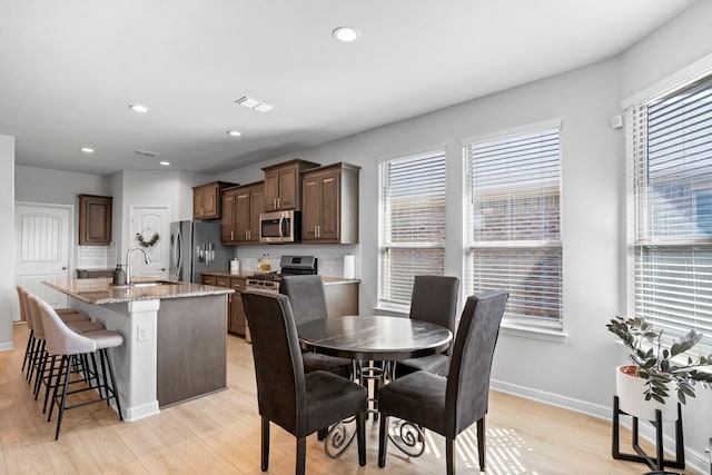 dining room with light wood-type flooring and sink