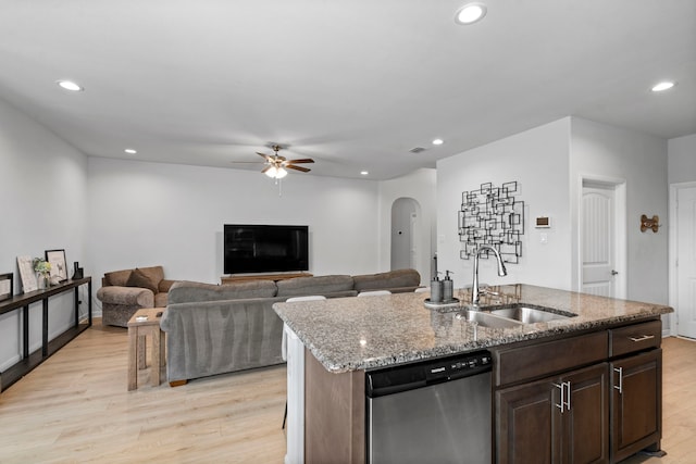 kitchen featuring dishwasher, a center island with sink, light wood-type flooring, and sink