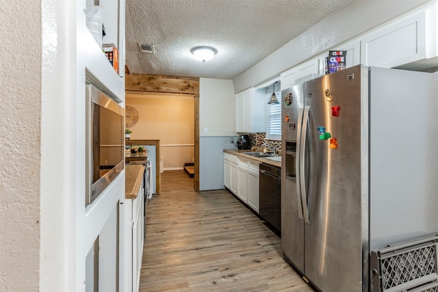 kitchen featuring sink, stainless steel fridge with ice dispenser, white cabinetry, dishwasher, and light wood-type flooring