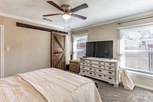 bedroom with ornamental molding, multiple windows, ceiling fan, and a barn door