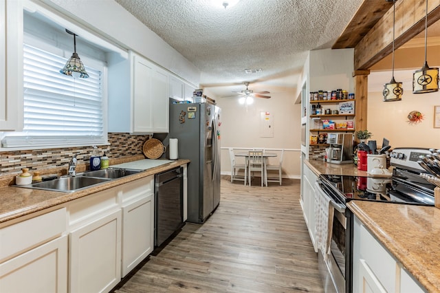 kitchen with pendant lighting, light hardwood / wood-style flooring, sink, white cabinets, and appliances with stainless steel finishes