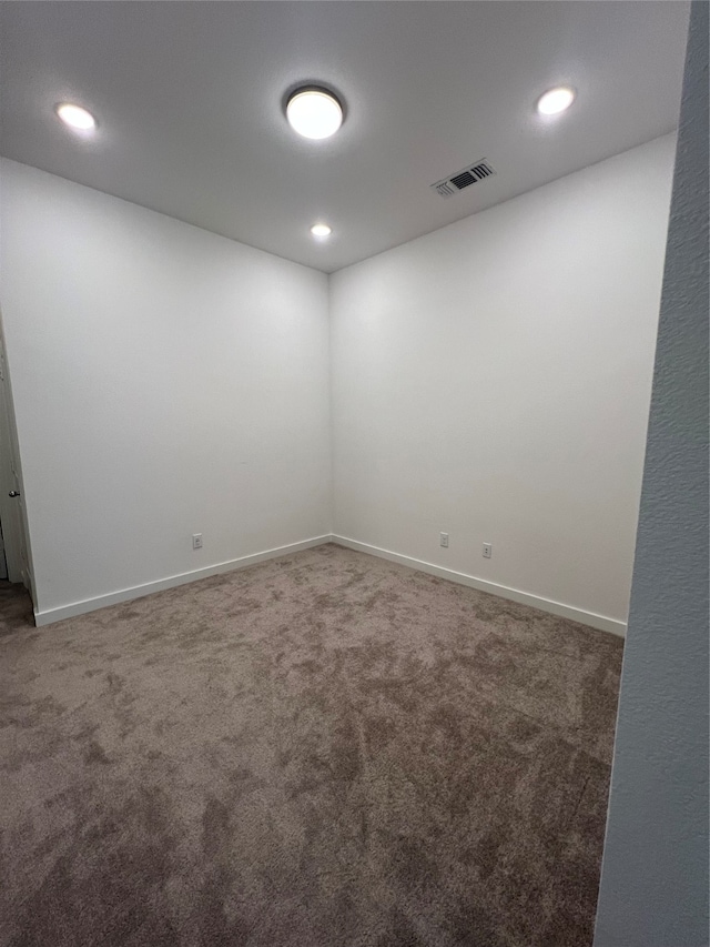 unfurnished room featuring dark carpet