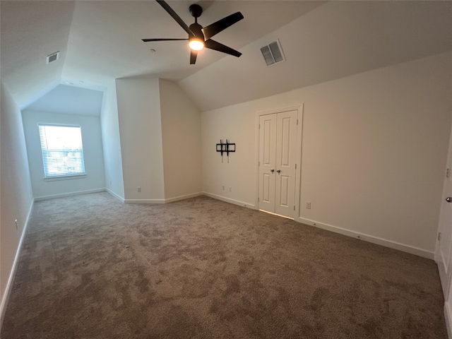 additional living space featuring lofted ceiling, dark carpet, and ceiling fan