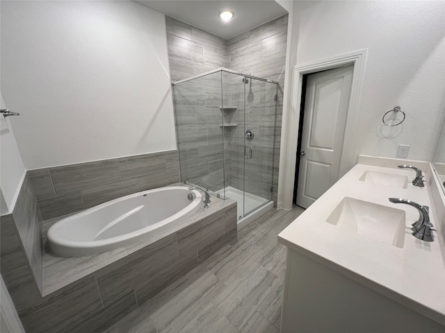 bathroom with vanity and shower with separate bathtub