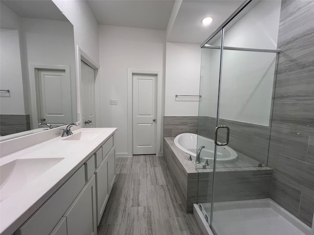 bathroom featuring shower with separate bathtub, hardwood / wood-style flooring, and vanity