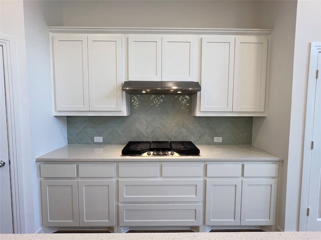 kitchen featuring decorative backsplash, stainless steel gas stovetop, and white cabinets