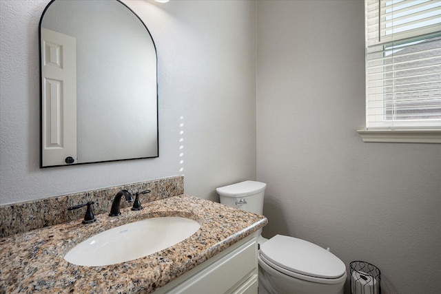 bathroom with vanity, a healthy amount of sunlight, and toilet