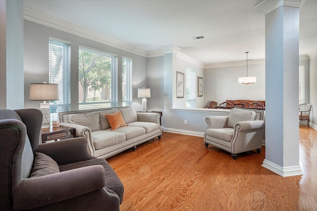 living room with a healthy amount of sunlight, light wood-type flooring, and crown molding