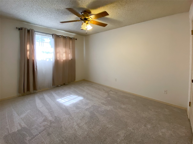 spare room with carpet, a textured ceiling, and ceiling fan